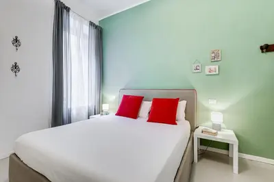 a bedroom with a large bed with two red pillows at Colosseo Exclusive House by Premium Suites Collection in Rome