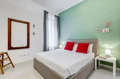 a bedroom with a bed with red pillows and a mirror at Colosseo Exclusive House by Premium Suites Collection in Rome