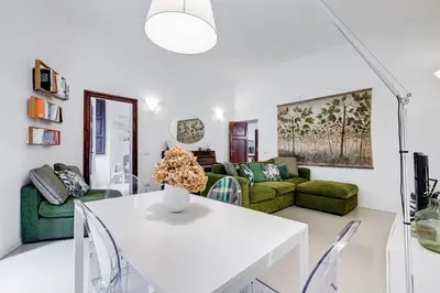 a living room with a white table and green furniture at Colosseo Exclusive House by Premium Suites Collection in Rome