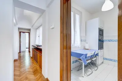 a white kitchen with a blue table in a room at Luminous Apartment few steps from Piazza Navona in Rome