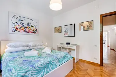 a white room with a bed and a desk at Luminous Apartment few steps from Piazza Navona in Rome