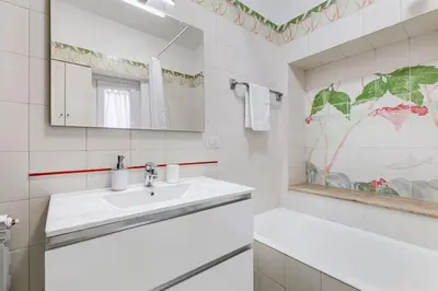 a white bathroom with a sink and a mirror at Luminous Apartment few steps from Piazza Navona in Rome