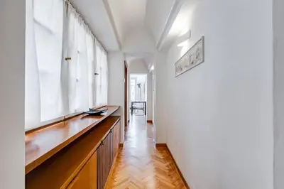 a hallway with white walls and a long wooden table at Luminous Apartment few steps from Piazza Navona in Rome