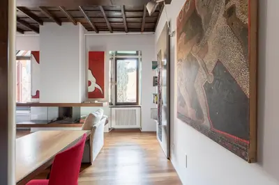 a dining room with a table and a painting on the wall at iFlat Loft&Pool in Trastevere in Rome