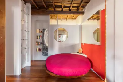 a large red ottoman in the middle of a room at iFlat Loft&Pool in Trastevere in Rome