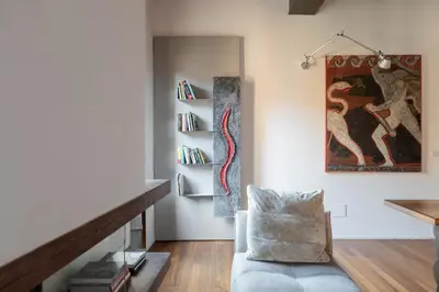 a living room with a couch and a book shelf at iFlat Loft&Pool in Trastevere in Rome