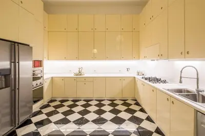 a kitchen with yellow cabinets and a checkered floor at Palazzo Berardi: Renaissance Downtown Luxury Villa in Rome
