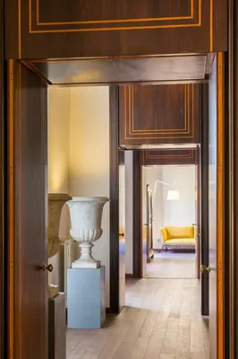 a hallway with a vase in the middle of a room at Palazzo Berardi: Renaissance Downtown Luxury Villa in Rome