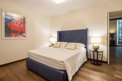 a bedroom with a large bed with a blue headboard at Palazzo Berardi: Renaissance Downtown Luxury Villa in Rome