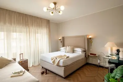 a hotel room with two beds and a desk at Daplace - Hotel Gran Torino Suites in Rome