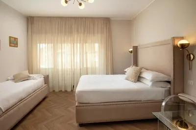 a bedroom with two beds and a window at Daplace - Hotel Gran Torino Suites in Rome