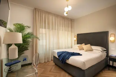 a bedroom with a large bed and a plant at Daplace - Hotel Gran Torino Suites in Rome