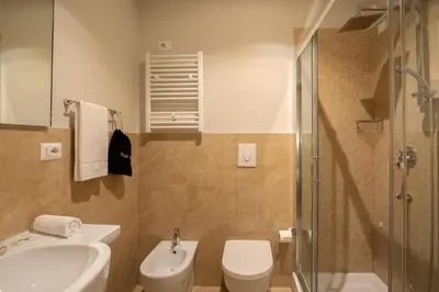 a bathroom with a toilet and a sink and a shower at Daplace - Hotel Gran Torino Suites in Rome