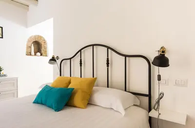 a bedroom with a bed with yellow and blue pillows at VII Coorte a Trastevere in Rome