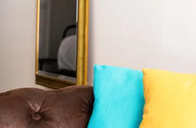 a mirror sitting next to a couch with a pillow at VII Coorte a Trastevere in Rome