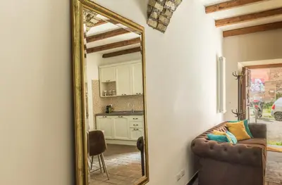 a mirror in a room with a couch and a kitchen at VII Coorte a Trastevere in Rome