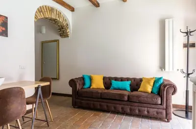 a living room with a brown couch with colorful pillows at VII Coorte a Trastevere in Rome