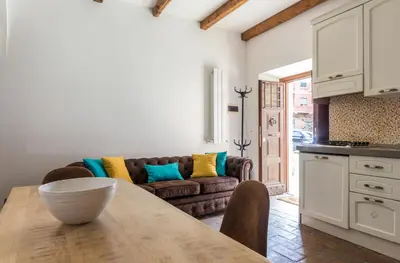 a kitchen and living room with a table and a couch at VII Coorte a Trastevere in Rome