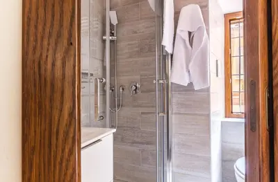a bathroom with a shower with a glass door at VII Coorte a Trastevere in Rome