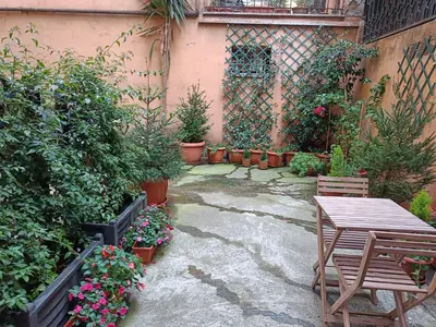 a garden with a table and chairs and potted plants at Suites in Rome in Rome