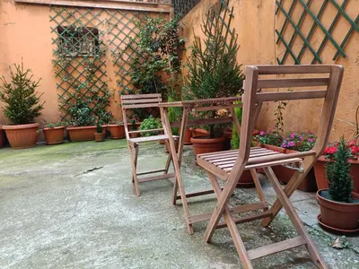 two wooden chairs sitting next to a bunch of potted plants at Suites in Rome in Rome