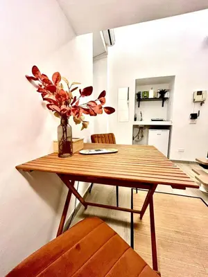 a dining room table with a vase of flowers on it at Katia Charme in Rome