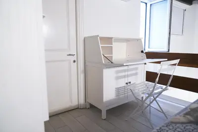 a white desk with a chair next to a window at Torretta Flat in Rome