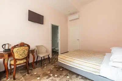 a bedroom with a bed and a desk and a table at Stevenson Rooms in Rome