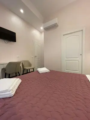 a room with a large bed and chairs and a tv at Stevenson Rooms in Rome