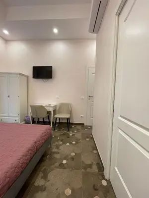 a room with a bed and a table and a tv at Stevenson Rooms in Rome
