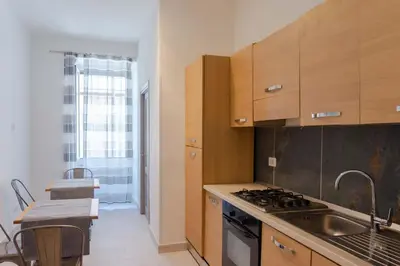 a kitchen with wooden cabinets and a sink and a stove at Le suite di Borgo in Rome