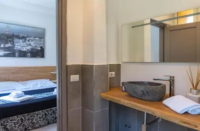 a bathroom with a sink and a bed and a mirror at Le suite di Borgo in Rome