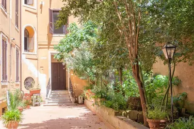 an alley with a building and a door and trees at Le suite di Borgo in Rome