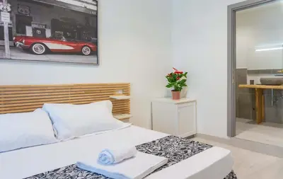 a bedroom with a white bed and a red car on the wall at Le suite di Borgo in Rome