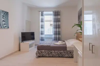 a small bedroom with a bed and a television at Le suite di Borgo in Rome
