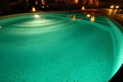 a large swimming pool at night with lights at La Valle dei Casali Green Boutique in Rome
