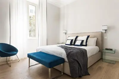 a bedroom with a bed and a blue chair at Idyllia - Elegant central flat in Rome