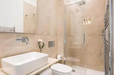 a bathroom with a white sink and a shower at Idyllia - Elegant central flat in Rome