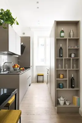 a kitchen with white cabinets and a wooden floor at Idyllia - Elegant central flat in Rome