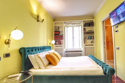 a bedroom with a blue bed with a window at Large and Charming Apartment in Trastevere by YourHost in Rome