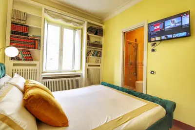 a bedroom with a bed and a window and a television at Large and Charming Apartment in Trastevere by YourHost in Rome