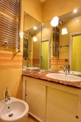 a bathroom with two sinks and a large mirror at Large and Charming Apartment in Trastevere by YourHost in Rome