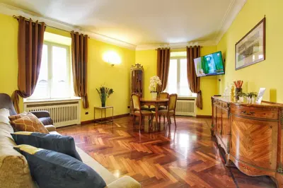 a living room with a couch and a table at Large and Charming Apartment in Trastevere by YourHost in Rome