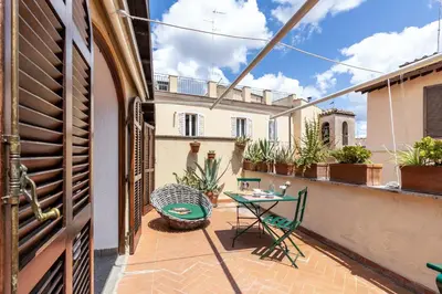 a patio with a table and chairs on a balcony at Rome As You Feel - Librari Penthouse with Terrace in Rome