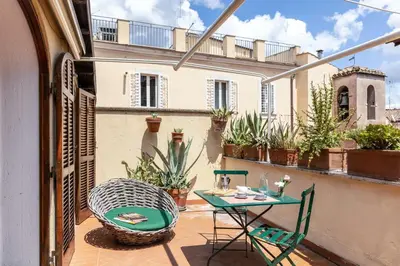a patio with a table and chairs on a balcony at Rome As You Feel - Librari Penthouse with Terrace in Rome