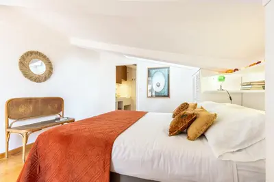 a white bedroom with a bed and a chair at Rome As You Feel - Librari Penthouse with Terrace in Rome