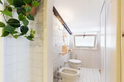 a bathroom with a toilet and a potted plant at Rome As You Feel - Librari Penthouse with Terrace in Rome