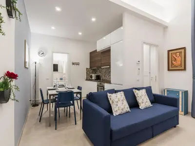 a living room with a blue couch and a table at The Best Rent - Two-bedroom apartment close to San Pietro in Rome