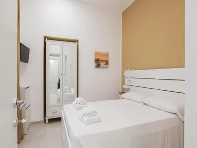 a white bedroom with two beds and a mirror at The Best Rent - Two-bedroom apartment close to San Pietro in Rome