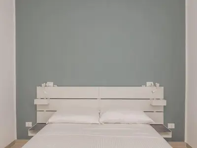 a white bed with a white headboard in a room at The Best Rent - Two-bedroom apartment close to San Pietro in Rome